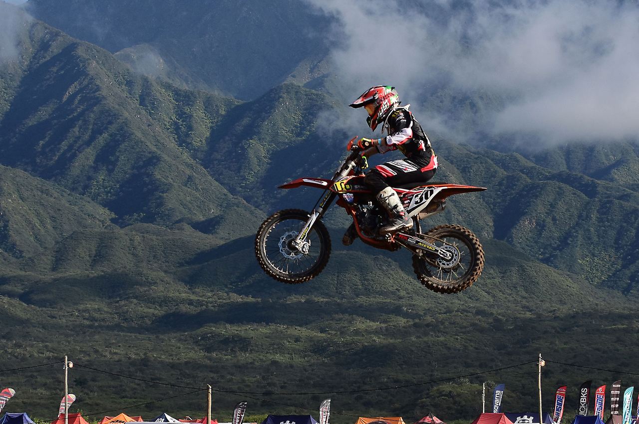 Piloto de motocross en pleno salto durante una carrera